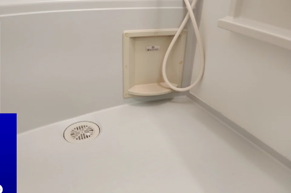 排水口とシャワーホースがある浴室の洗い場